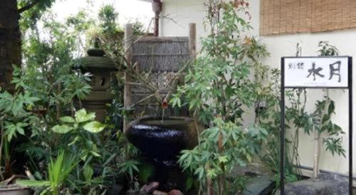 a garden with a large vase and some plants at Suigetsurou Hotel in Takaoka