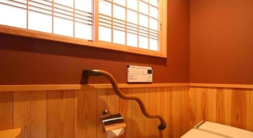 a bathroom with a toilet and a window at Suigetsurou Hotel in Takaoka