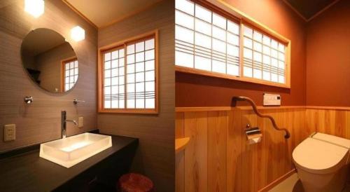 a bathroom with a sink and a toilet and a mirror at Suigetsurou Hotel in Takaoka