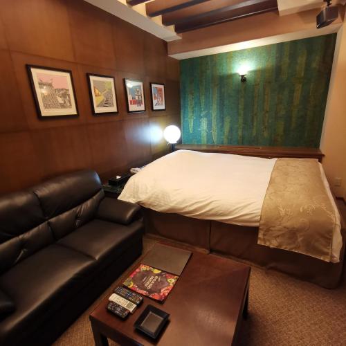 a hotel room with a bed and a couch at ホテル マリオン 鈴鹿 in Suzuka
