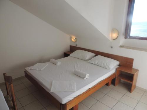 a bed with white sheets and pillows in a room at Villa Ana in Bol