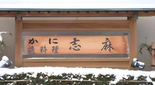 a sign with asian writing on the side of a building at Minshuku Shima in Kaga