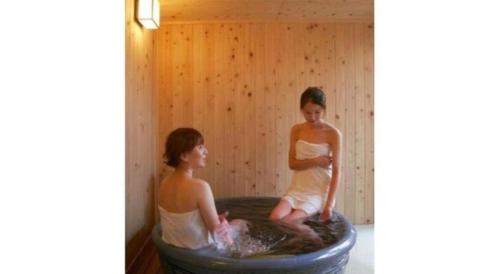 two women sitting in a tub in a sauna at Hirata Maple Hotel in Izumo
