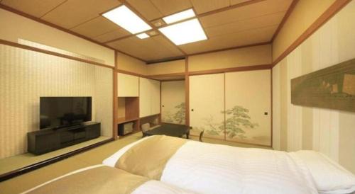 a bedroom with a bed and a television in it at Centurion Hotel Technoport Fukui- Artificial Radium Hot Spring in Sakai