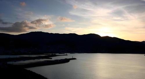 a view of a body of water with the sun setting at Luxury Wa Hotel Kaze No Kaori in Ito