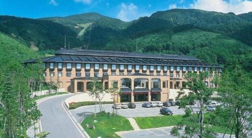 a large building in front of a mountain at Hotel de Premiere Minowa in Inawashiro