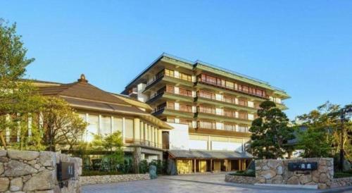a large building with a stone fence in front of it at Shiratamano Yu Senkei in Shibata