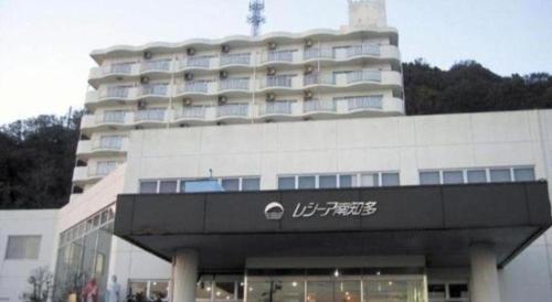 a large white building with a sign in front of it at Hotel Resea Minamichita in Minamichita