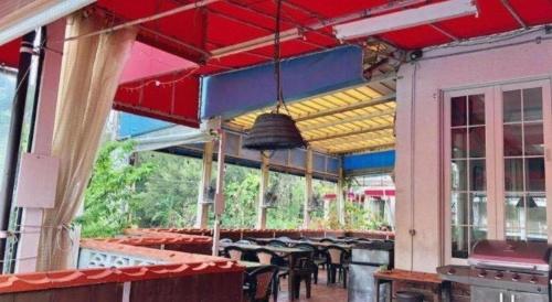 a restaurant with tables and chairs on a patio at Petit Hotel Key West Club in Naha
