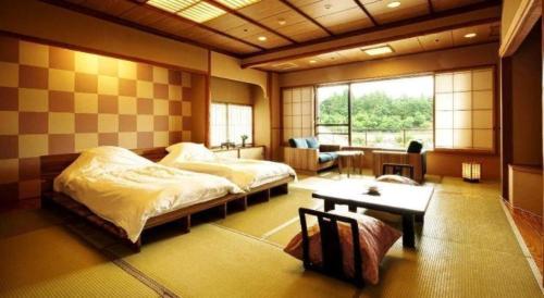 a bedroom with two beds and a table in it at Shiratamano Yu Senkei in Shibata