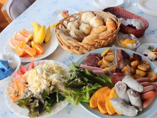 a table with plates of food and baskets of bread at Petit Hotel Hoshi no Shizuku in Kitashiobara
