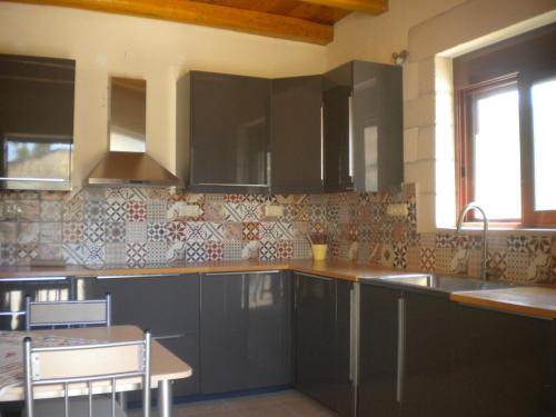 a kitchen with gray cabinets and a table and a sink at Marias Alikambos in Alikampos