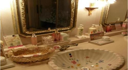 a bathroom counter with a sink and a mirror at Tsukino Sumika Atami Juraku Hotel in Atami