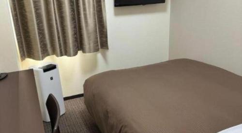 a bedroom with a bed and a window at E Hotel Kumagaya Annex in Kumagaya