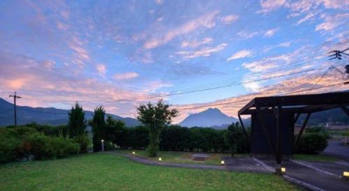 a sunset view of a park with mountains in the background at Yufuin Matousou in Yufuin