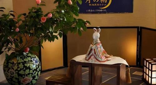 a statue of a bunny sitting on a table next to a vase at Tsukino Sumika Atami Juraku Hotel in Atami