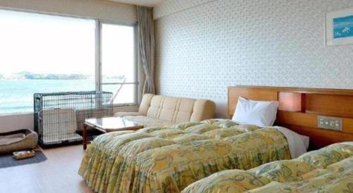 a hotel room with two beds and a couch at Hamanako Lake Side Plaza in Hamamatsu