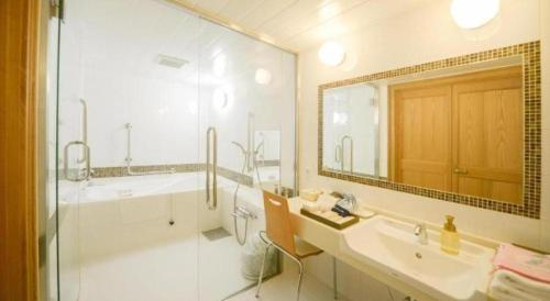 a bathroom with a tub and a sink and a shower at Hamanako Lake Side Plaza in Hamamatsu