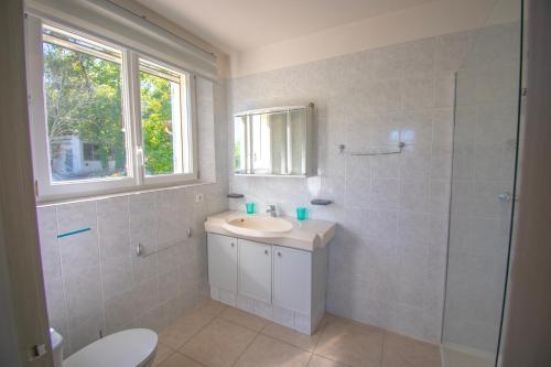 a white bathroom with a sink and a shower at Charmante villa avec grande piscine au calme in Callian