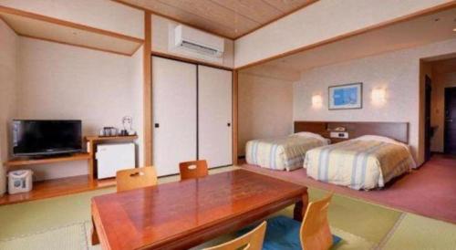 a room with two beds and a table and a bedroom at Hamanako Lake Side Plaza in Hamamatsu
