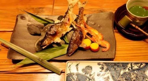 a plate of food with seafood on a cutting board at Myoken Ishiharaso in Kirishima