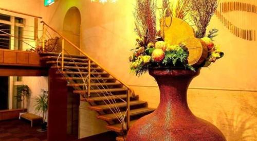 a large red vase with a bunch of fruits and flowers at Yukemuri no sato azumaya in Beppu