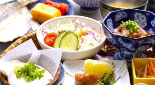 a table with bowls of food on a table at Yukemuri no sato azumaya in Beppu