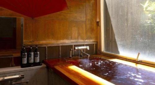 a kitchen with a sink and a window at Yukemuri no sato azumaya in Beppu