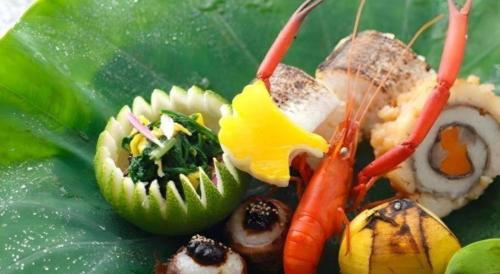 a plate of food with vegetables on a leaf at Myoken Ishiharaso in Kirishima