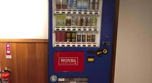 a blue vending machine filled with bottles of alcohol at HotelNewYama in Yamanouchi