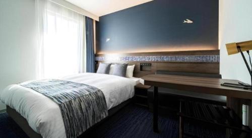 a hotel room with a bed and a desk at Goto Tsubaki Hotel in Goto