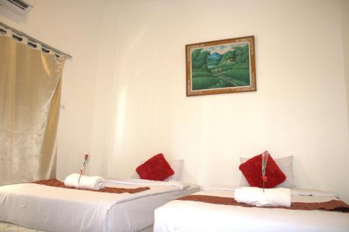 two beds with red pillows in a room at Joya House Uluwatu in Uluwatu