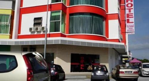 a building with cars parked in front of it at Hotel Kristal in Seri Iskandar