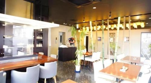 a dining room with a table and white chairs at Chino Station Hotel in Chino