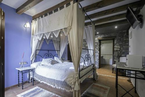 - une chambre avec un lit à baldaquin dans l'établissement Hotel Rural Mañe, à Mallavia