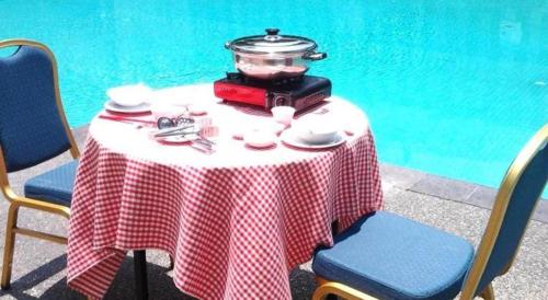 a table with a red and white checkered table cloth at Century Helang Hotel in Pantai Cenang