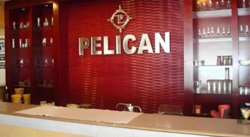 a red wall with a sign that says pelican at Pelican Hotel in Batu Pahat