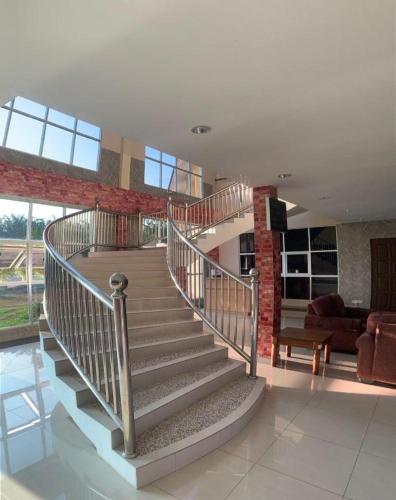 a spiral staircase in a room with a living room at PAHANG REST HOUSE @ BERA in Temerloh