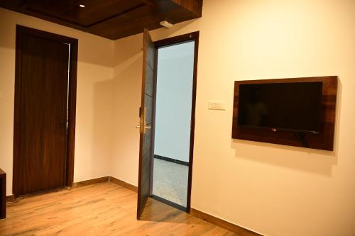 a room with a flat screen tv on the wall at Hotel Dwaraka in Kaglipur