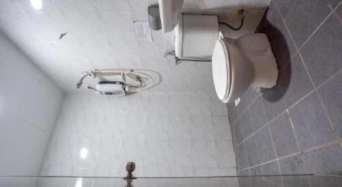 a bathroom with a toilet and a toilet paper dispenser at OYO 89895 Senses Budget Hotel in Banting