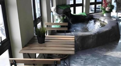 a bench next to a pond in a house at Sherrinton Hotel in Mentekab