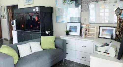 a living room with a gray couch and a window at Sherrinton Hotel in Mentekab