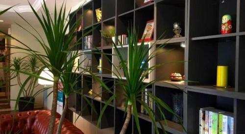 a book shelf with a plant in a room at The Regency Hotel Seri Warisan in Taiping