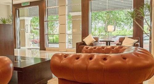 a living room with a leather couch and a table at The Regency Hotel Seri Warisan in Taiping