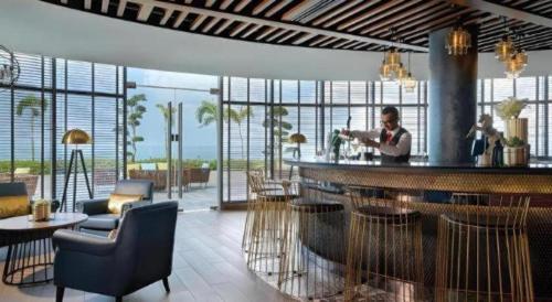 a man sitting at a bar in a hotel lobby at Hatten Place Melaka in Melaka