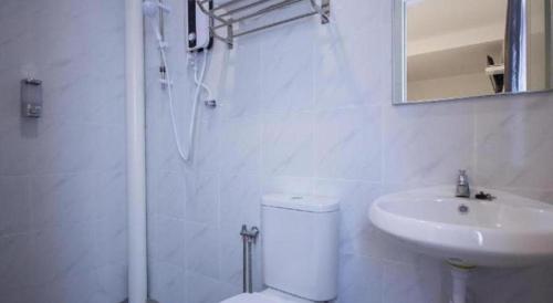 a white bathroom with a toilet and a sink at D Nice Hotel in George Town