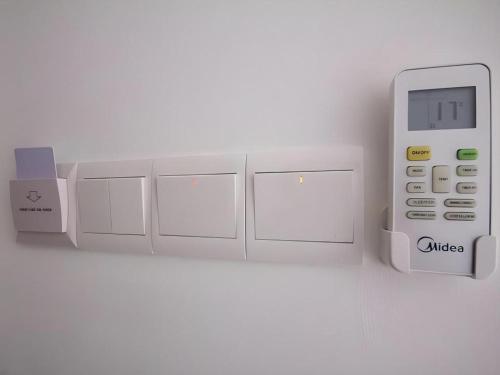 an electronic device with a remote control on a wall at D Nice Hotel in George Town
