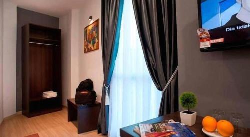 a living room with a glass table and a window at Big Orange Hotel Jitra in Alor Setar