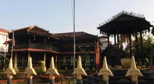a building with straw umbrellas in front of it at OYO 718 Mr J Hotel Wakaf Che Yeh 1 in Kota Bharu