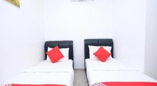 two chairs with red pillows sitting in a room at OYO 718 Mr J Hotel Wakaf Che Yeh 1 in Kota Bharu